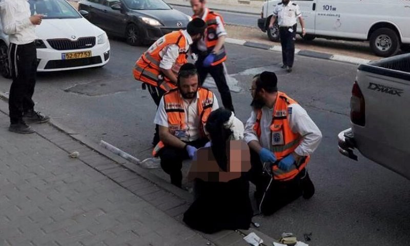 מתנדבים חרדים מטפלים באישה שהותקפה הערב בבית שמש (פייסבוק קארין אסרף)