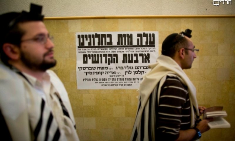 עטורים טלית ותפילין בבית הכנסת בני תורה אמש. צילום: פלאש 90 