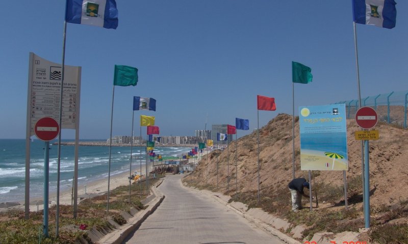 חוף הרצליה. למטה: המודעות שניתלו בעיר, הבוקר. צילום: דוד קורן