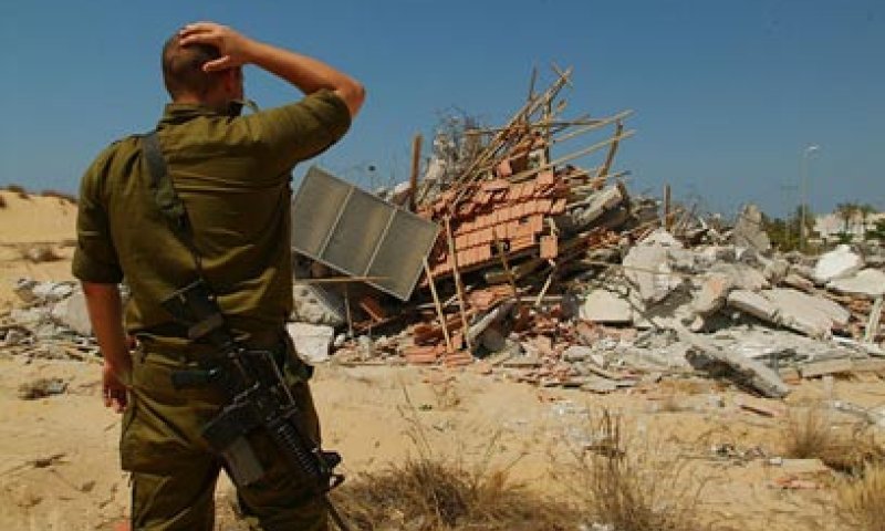 חייל צה"ל על רקע בית שנהרס בגוש קטיף. אחד מצילומיו המפעימים של ישראל ברדוגו
