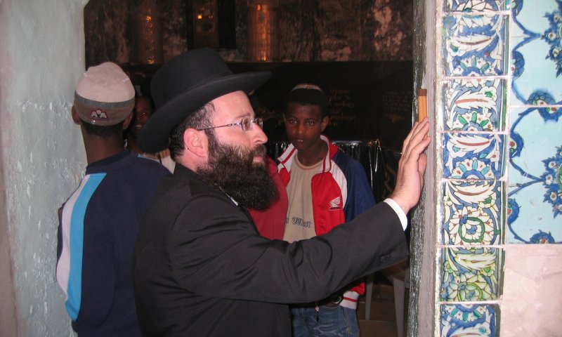 הרב שמואל רבינוביץ קובע מזוזה בשער החדש שנפרץ לכניסת גברים בלבד