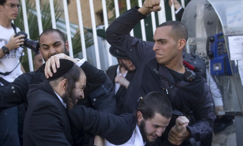 שוטר מכה מגפין חרדי, היום בירושלים (יונתן זינדל, פלאש 90)