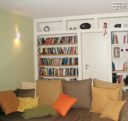בתמונה: ריפוד ספה בצבע רגוע, כריות צבעוניות בצבעים בולטים יותר.
