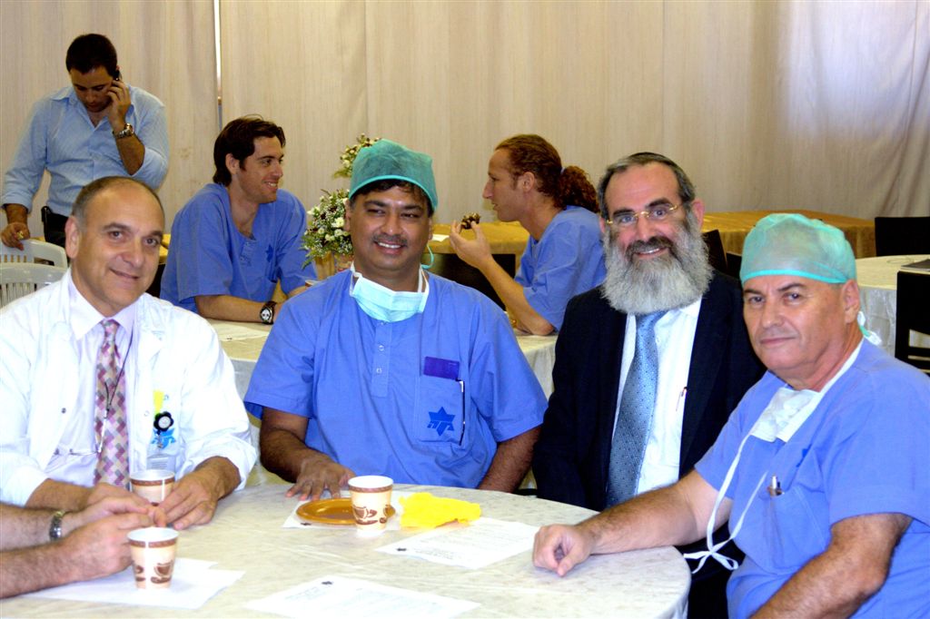 המנתח וחברי צוות בית החולים בהפוגה שבין הניתוחים (צילום: ד"ר מרי אקרי )