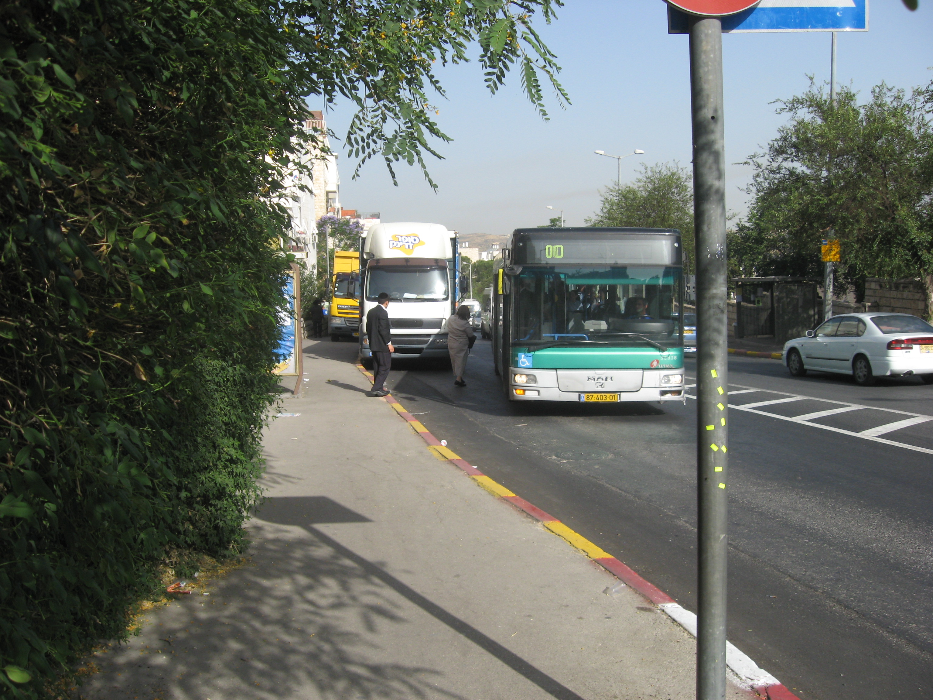 המשאיות מאלצות את האוטובוס לעצור במרחק רב מהמדרכה