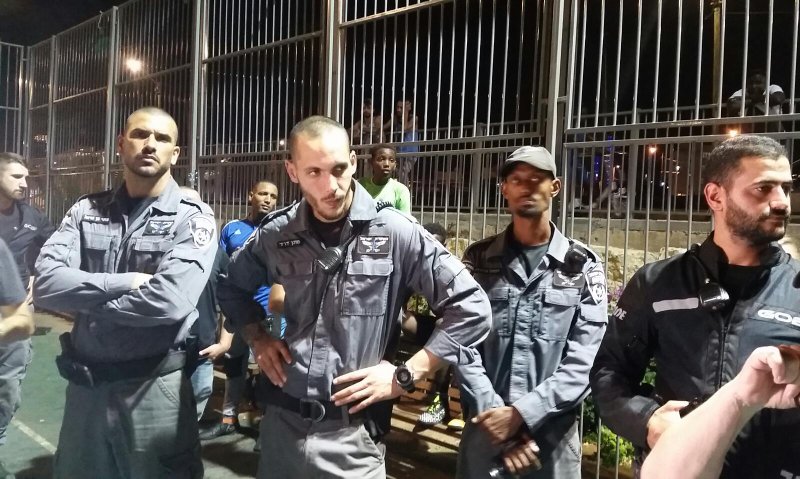 השוטרים מגנים על מסתננים  מול המפגינים